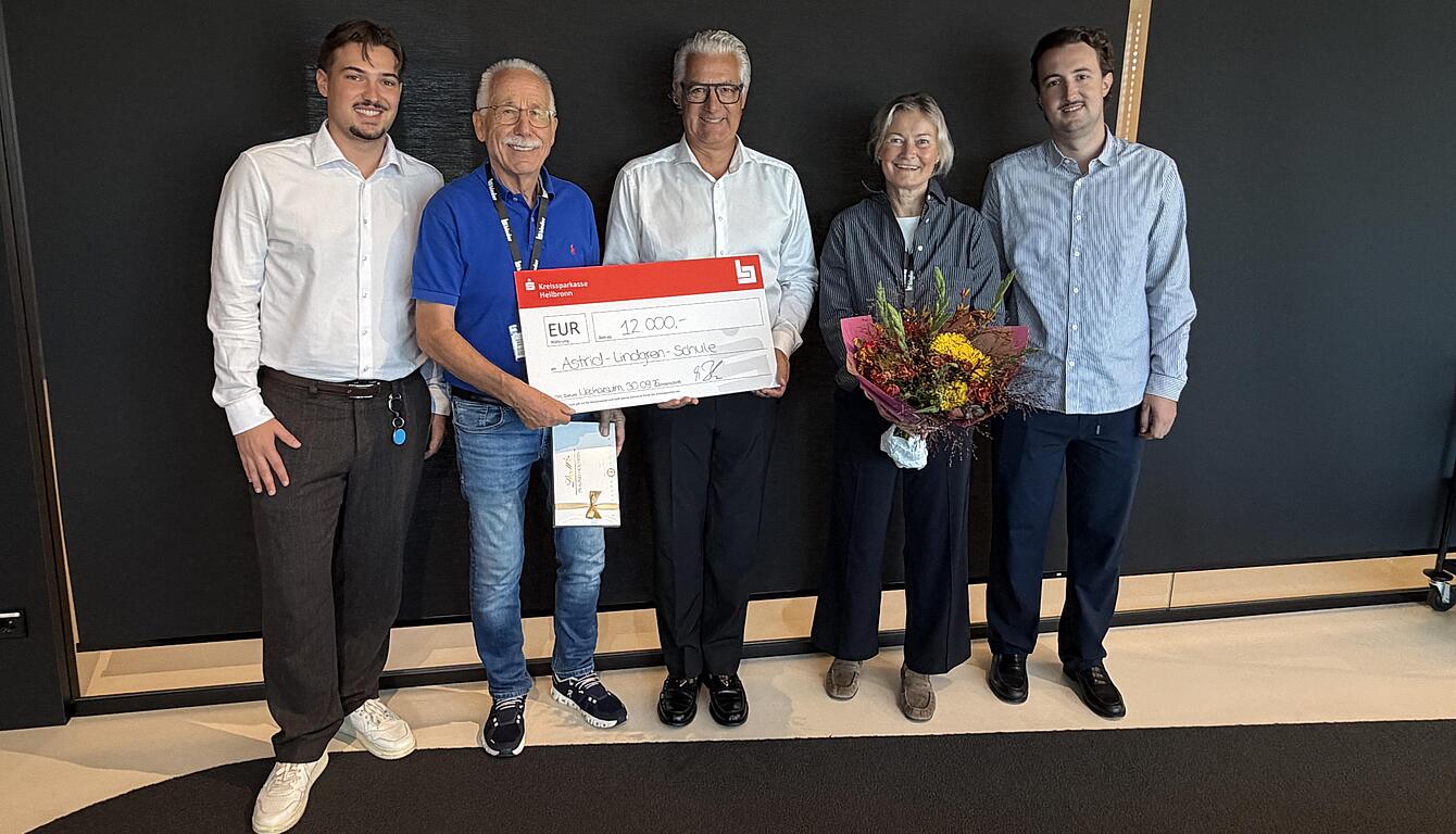 Fünf Personen mit Spendenscheck bei der Spendenübergabe an die Astrid-Lindgren-Schule im binder Headquarter in Neckarsulm